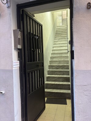 A staircase leading to an upper floor, a security gate, and a wall-mounted intercom system. - Sorrento Suite with private bathroom near the historic center (Napoli)