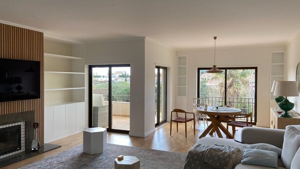 Un salón amplio con chimenea, una mesa de comedor con sillas y un sofá.