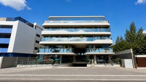 A multi-story hotel with a modern design, featuring a glass facade and a prominent entrance. - Setai Yatch Garden  (João Pessoa)