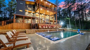 Un edificio de varios pisos con piscina, mobiliario exterior y una terraza de madera.