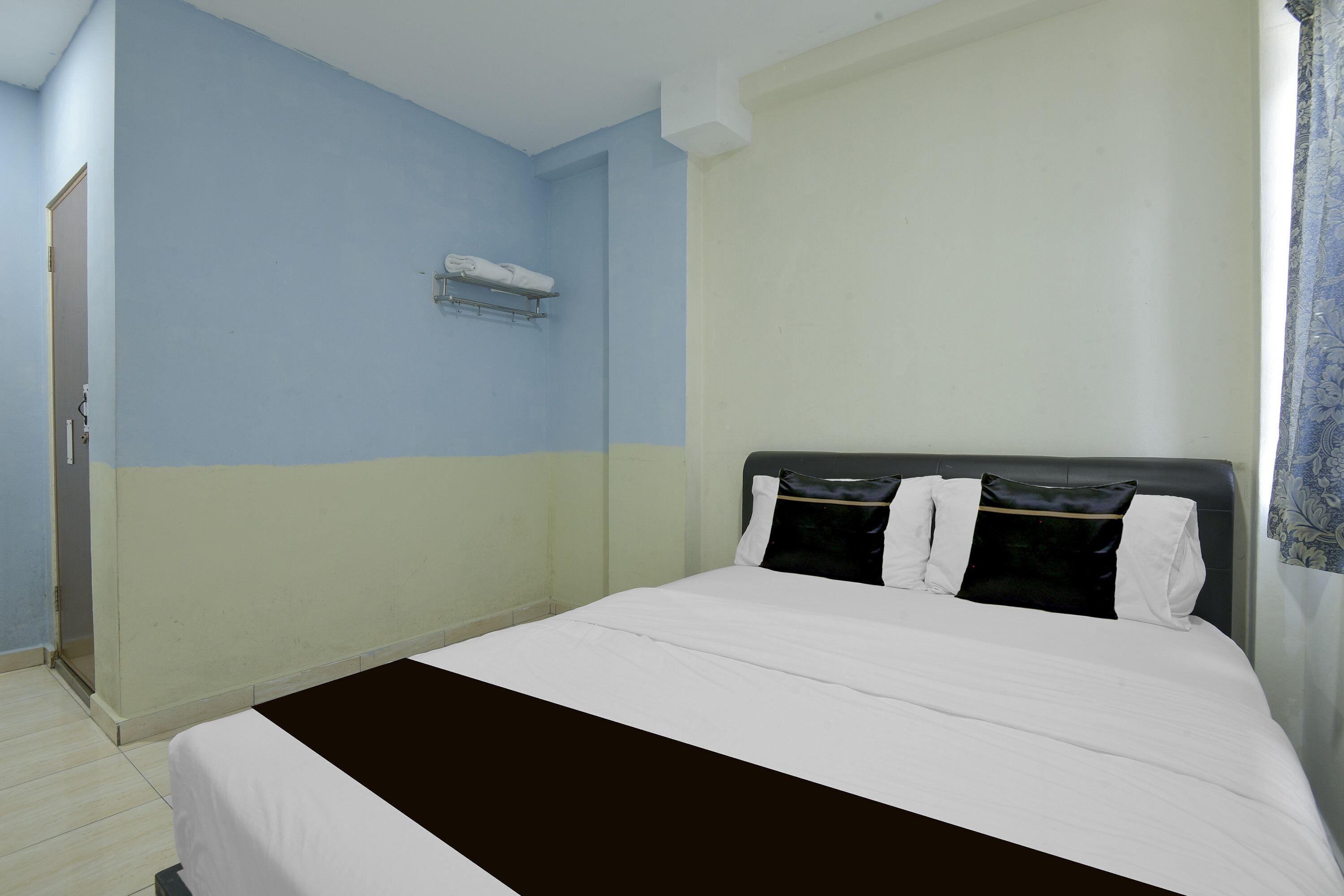 Un dormitorio con cama, aire acondicionado de pared y una puerta.