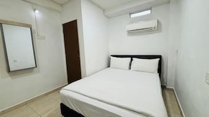 Un dormitorio con cama, aire acondicionado de pared, una puerta y una lámpara.