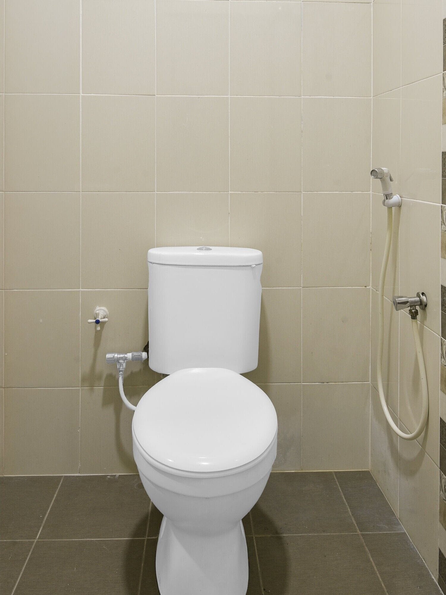 Un baño con inodoro, ducha y grifo empotrado.