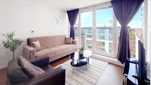 A modern living room with a sofa, a coffee table, and a plant.