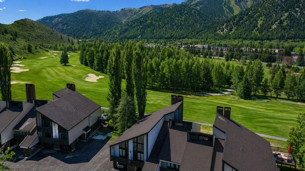 A residential area with modern houses, a golf course, and a mountainous backdrop. - Classic Sun Valley on Hole 1 | Golf Course + Baldy Views (Ketchum)
