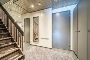 Ein modernes Interieur mit einer Holztreppe, einem Spiegel und zwei Türen.