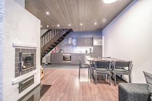 Une cuisine moderne avec un coin repas, un plancher en bois et un escalier.