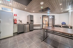 Een moderne keuken met roestvrijstalen apparatuur, een brandblusser en een betegelde vloer.