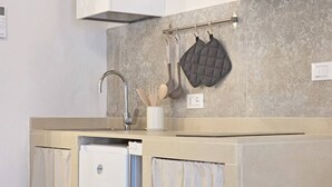 Une cuisine équipée d’un robinet moderne, d’un porte-ustensiles suspendu et d’un lave-vaisselle.