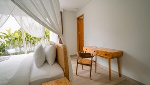 Une chambre à coucher avec un lit, un bureau en bois, une chaise et une petite table.