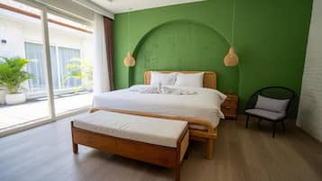 Ein Schlafzimmer mit Bett, Bank, Stuhl und großen Fenstern.
