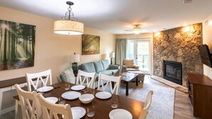 Un comedor con una mesa preparada para cuatro personas, un sofá y una chimenea.