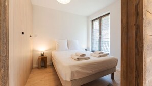 Una camera da letto con un letto, un comodino e una finestra con tende.