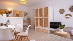 Un salon moderne comprenant un coin repas, un téléviseur et un canapé.