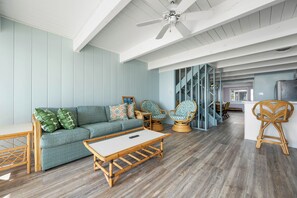 A spacious living area with a sofa, chairs, a coffee table, and a ceiling fan. - Oceanfront townhome on 78th Street offering multiple levels of living (Ocean City)