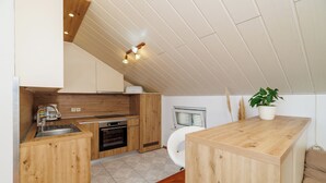 Une cuisine avec des meubles de rangement en bois, un évier et une cuisinière.