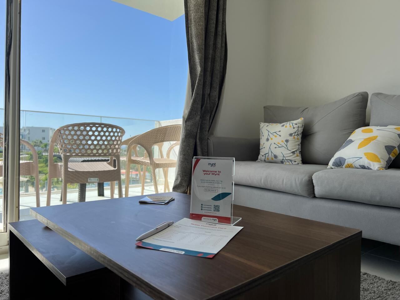 Una habitación con un sofá, una mesa de centro de madera, un cartel y una silla.