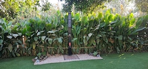 A garden with a black signpost, surrounded by lush green foliage.