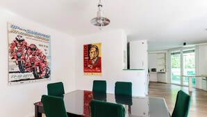 Ein Essbereich mit Tisch, Stühlen und zwei Bildern an der Wand.