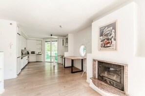 A spacious living area with a fireplace, a kitchen with white cabinets, and a dining table. - Detached house with swimming pool (MOLINI POOL HOUSE) (Maroggia)