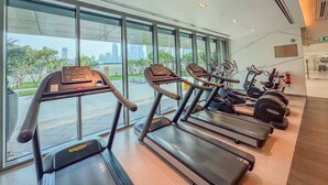 Une salle de sport équipée de tapis de course, de vélos d’appartement et d’appareils de musculation.