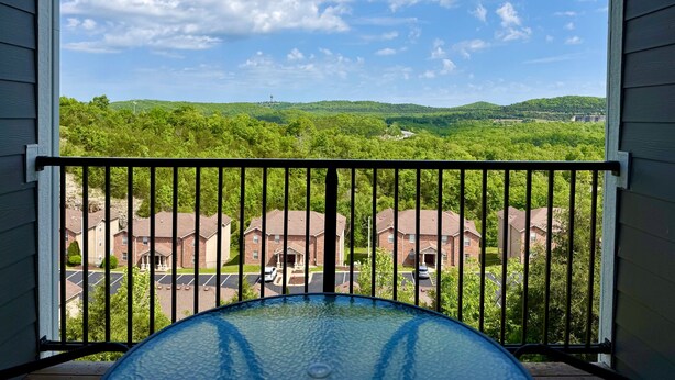 Un balcone con vista su una zona residenziale e una collina.