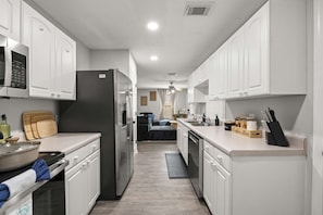 A modern kitchen with white cabinets, stainless steel appliances, and a central island.