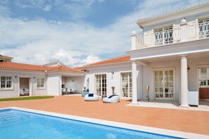 A poolside area with a swimming pool, white columns, and a balcony with a railing. - Villa Lea-casa del Sole Zadarvillas (Tar-Vabriga)