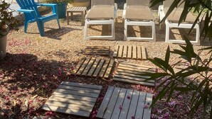 A patio area with wooden deck, lounge chairs, and potted plants. - Villa Spacieuse Avec Piscine Priv e 150 m de la Plage Calvi Centre (Calvi)