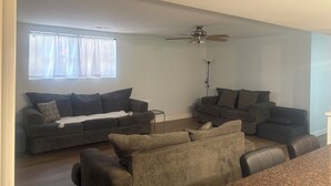 A living room with two sofas, a coffee table, and a ceiling fan.