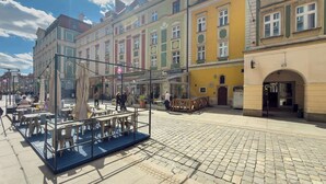 A cobblestone plaza with outdoor seating and colorful buildings in the background. - Functional Studio in the Center | Close to the Market | Smart TV (Wrocław)