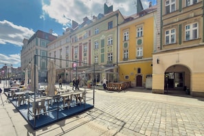A cobblestone plaza with outdoor seating and colorful buildings in the background. - Functional Studio in the Center | Close to the Market | Smart TV (Wrocław)