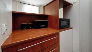 A compact kitchenette with a microwave, a bread box, and sugar and tea containers. - Functional Studio in the Center | Close to the Market | Smart TV (Wrocław)
