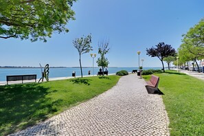 A paved pathway with benches, trees, and lampposts along a waterfront. - Apartment 'Casa Verde Rio' with Balcony, Wi-Fi and Air Conditioning (Vila Real de Santo António)