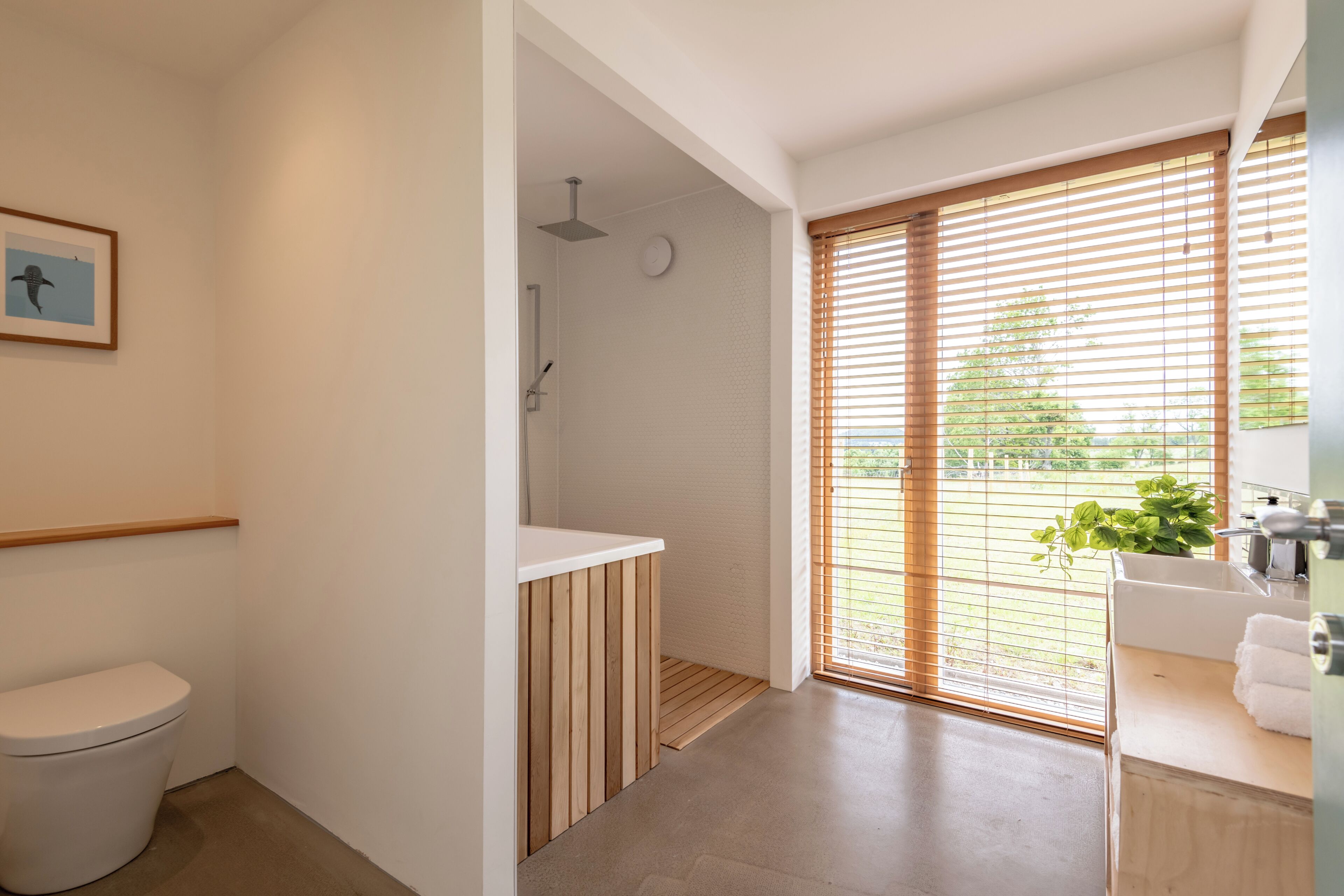 Et moderne badeværelse med toilet, brusebad og vask.
