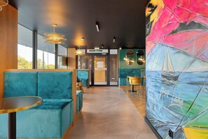 A modern interior with teal seating, a mural of a sailboat, and a wooden reception desk. - Apartment by the Forest | Close to the Beach (Mielno)