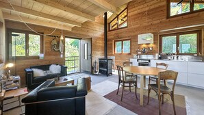 L’intérieur d’une cabane en bois comprend un espace de vie, une table à manger et une cuisine.
