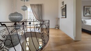 A staircase with ornate metal railings and crystal chandeliers, leading to a bedroom with a bed and a framed picture on the wall. - Villa Lea - Casa del Sole (Tar-Vabriga)