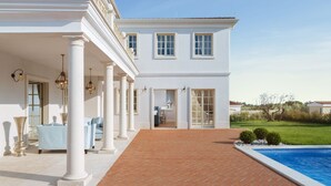 A large white building with columns, a brick patio, and a swimming pool. - Villa Lea - Casa del Sole (Tar-Vabriga)