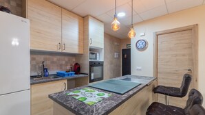 Une cuisine moderne avec des meubles en bois, un four à micro-ondes encastré et un îlot central doté de sièges.