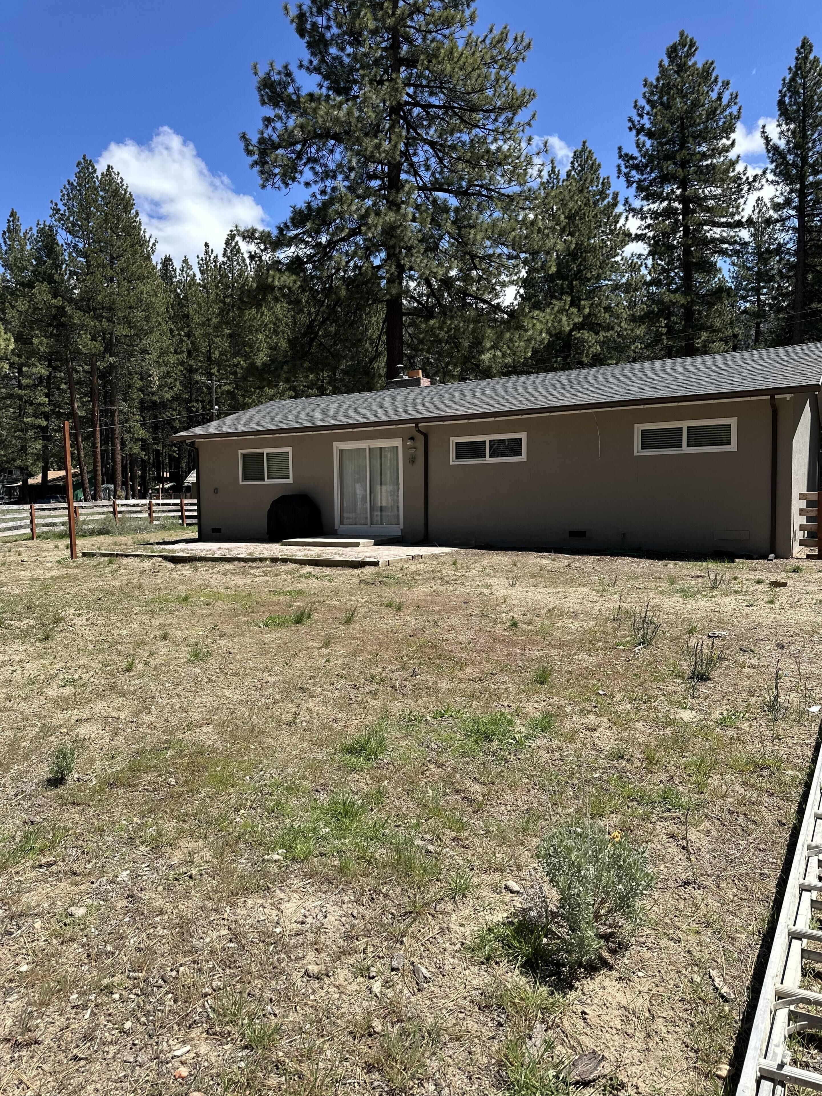 A single-story building with a flat roof, a garage door, and a small porch area.
