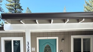 Una casa con una puerta azul turquesa, un buzón y el número 3381 en la pared.