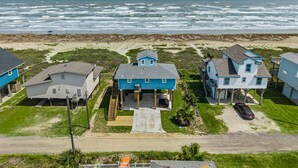 A coastal residential area with houses, a beach, and the ocean. - Beachfront | 3BR | Deck + Gulf Views (Galveston)
