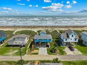 A coastal residential area with houses, a beach, and the ocean. - Beachfront | 3BR | Deck + Gulf Views (Galveston)