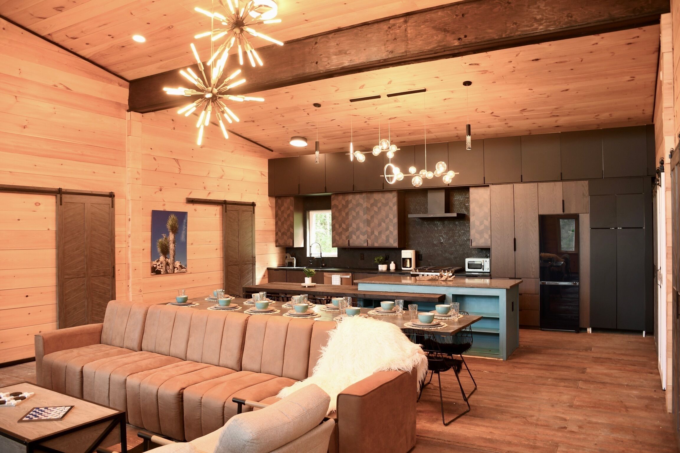 A modern interior with a wooden ceiling, a central island with seating, and a kitchen area.