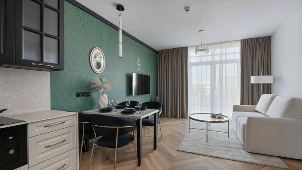 Una sala de estar moderna con comedor, sofá, televisor y chimenea.