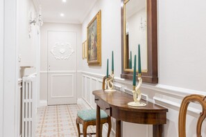 A hallway with a wooden dining table, chairs, a mirror, and a door. - Spacious and elegant 150 sq m apartment, perfect for six people, located on the first floor of a period building with an elevator (NOT accessible to disabled guests).The property is located in the heart of Montecatini Terme's historic center (pedestrian  (Montecatini Terme)