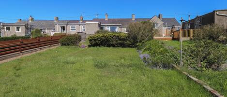 A residential area with houses, a grassy lawn, and a wooden fence.