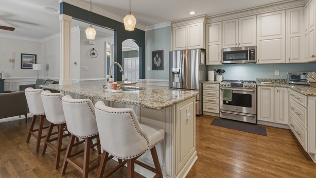 A modern kitchen with a central island, stainless steel appliances, and a seating area with bar stools. - Spacious home in safe and accessible area! Close to Hull Street, TurnPike, & RVA (Midlothian)