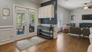 A spacious living area with a wooden floor, a gray sofa, a dark wooden console table, and a ceiling fan. - Spacious home in safe and accessible area! Close to Hull Street, TurnPike, & RVA (Midlothian)